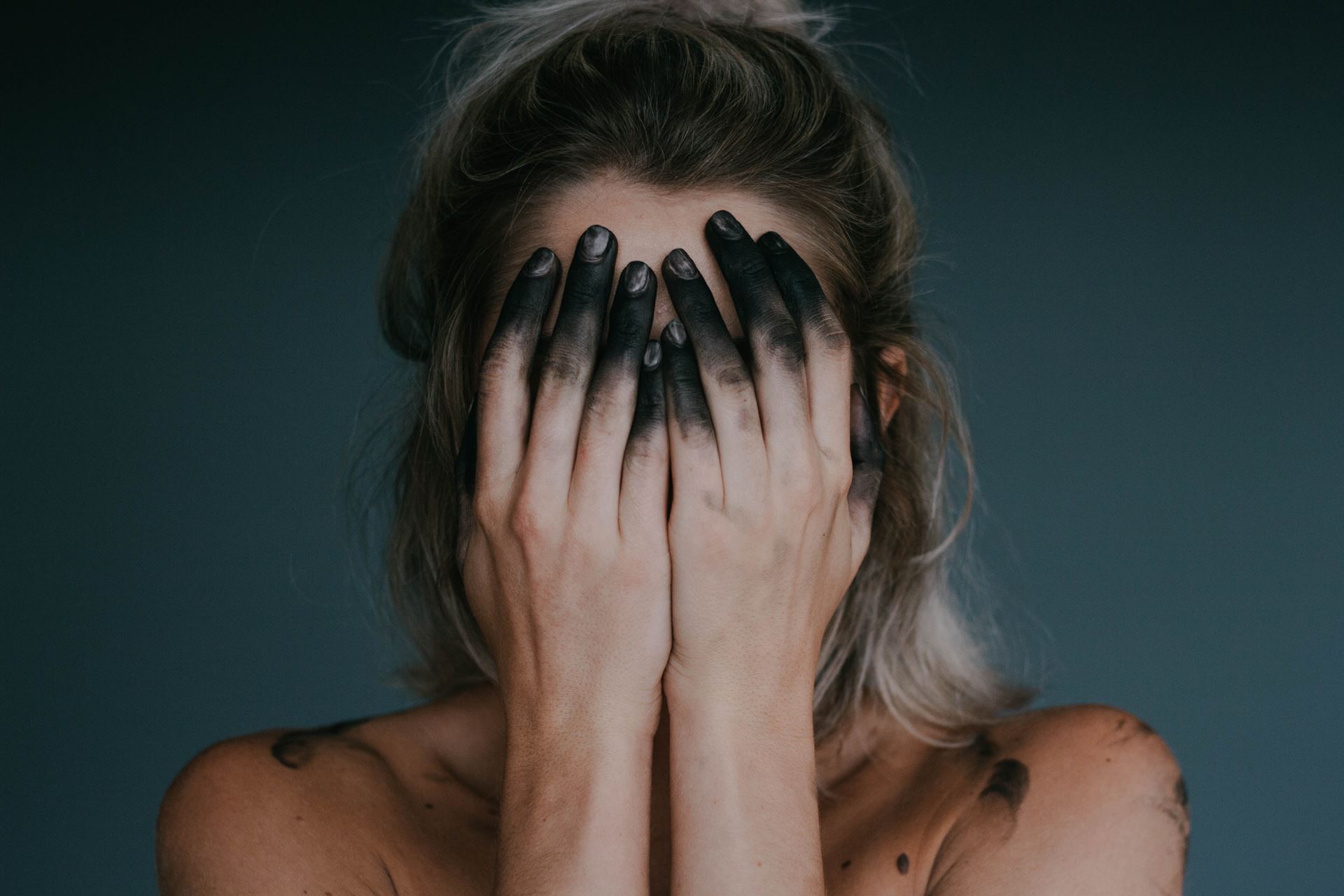 a woman with her hands covering her face
