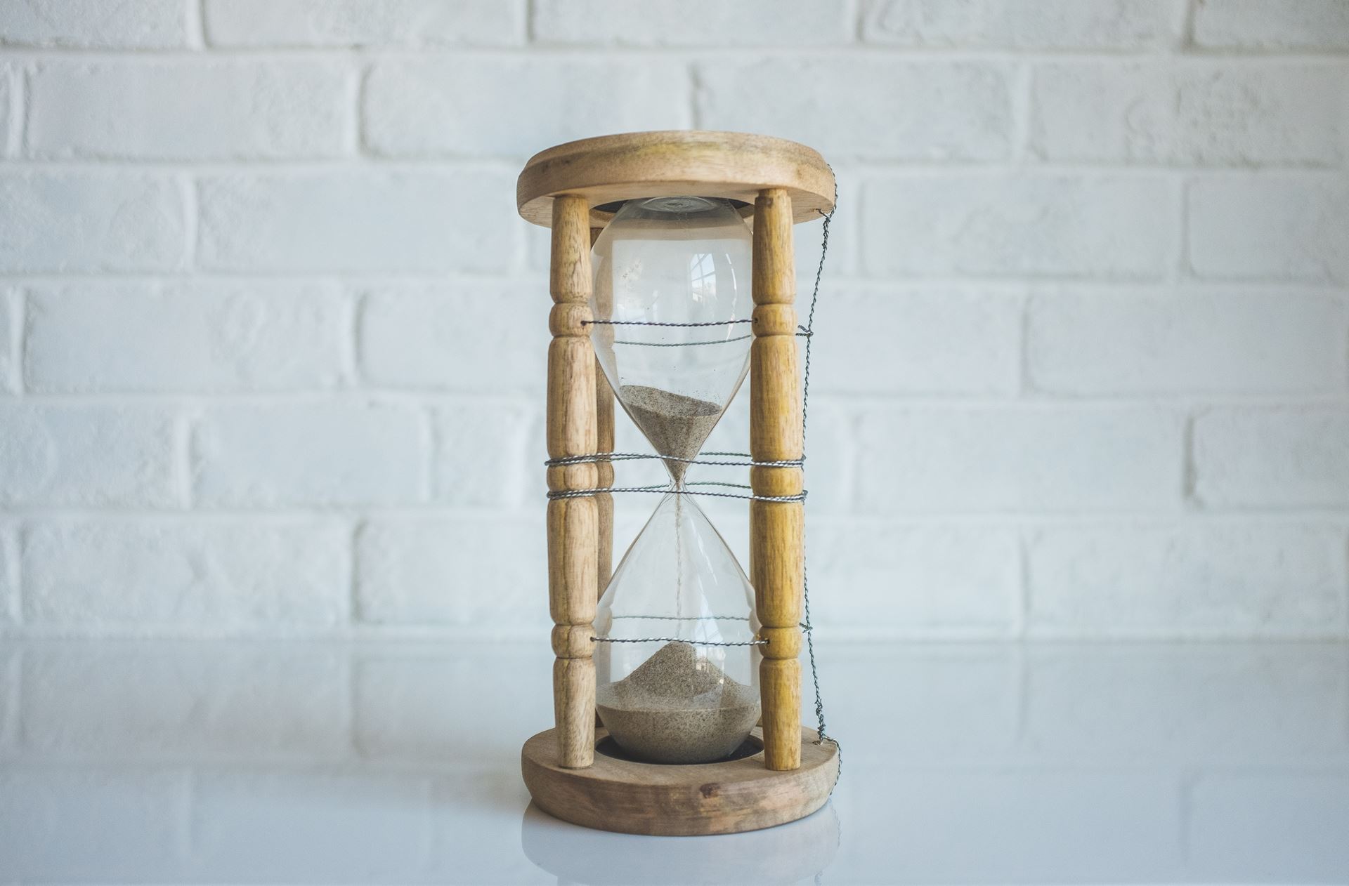an hourglass in front of a white brick wall